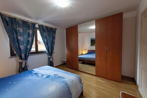 Une chambre à coucher avec un lit, une armoire et un miroir.