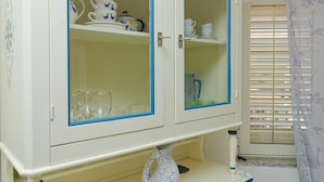 A white cabinet with blue trim, containing glassware and dishes. - Mermaid - Cala Gonone (Cala Gonone)