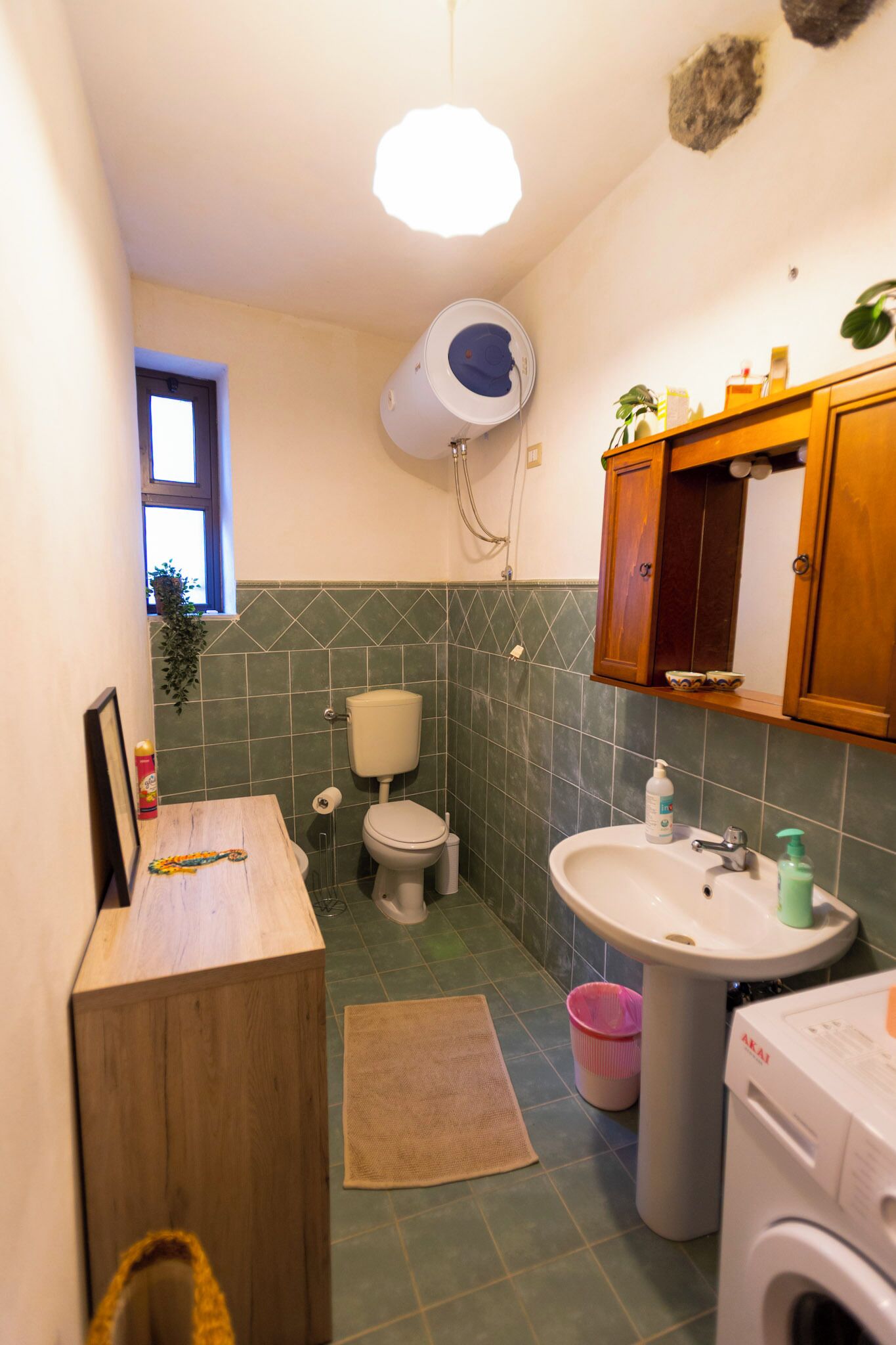 Un baño pequeño con inodoro, lavamanos y lavadora.