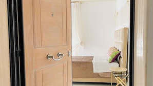 A bedroom with a bed, a bedside table, a chair, and a wardrobe. - Mora Suite (Bari)
