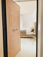 Una camera da letto con un letto, un comodino, una sedia e un armadio.