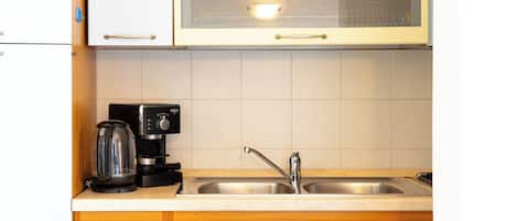 Een koelkast met diepvriezer, een oven, een kookplaat