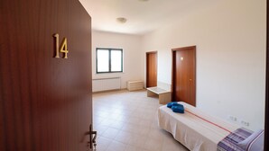 Une chambre avec un lit, une fenêtre et une porte portant le numéro 14.