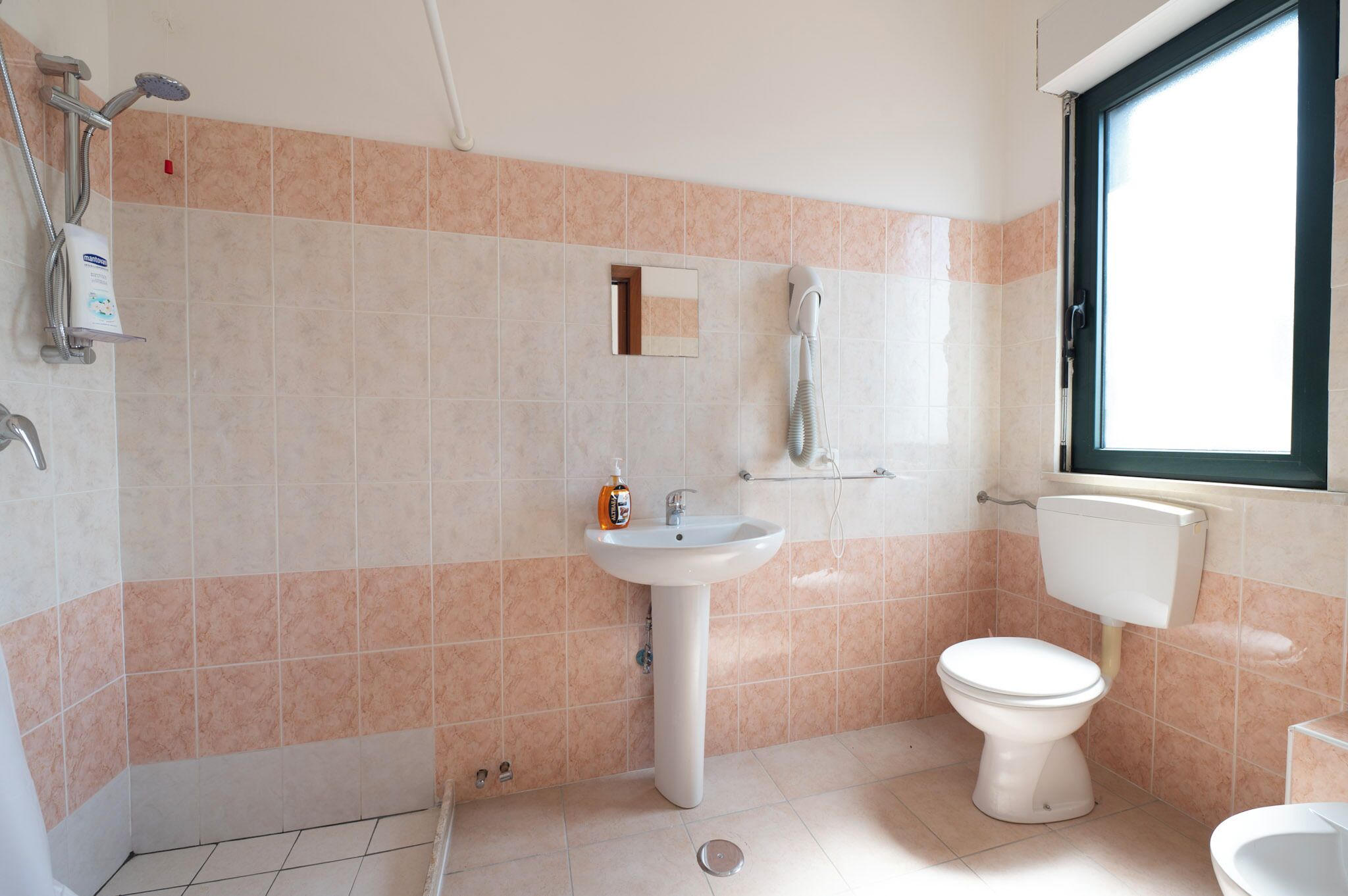 A bathroom with a sink, toilet, and shower.
