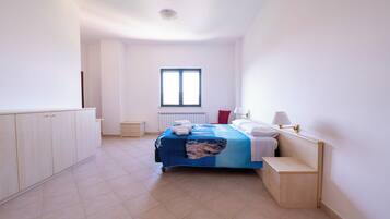 A bedroom with a bed, bedside tables, a window, and a radiator.