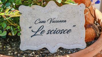 A sign with the text 'Casa Vacanza Le sciosce' in a terracotta pot.