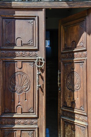 A wooden door with intricate carvings and a brass handle. - Le Sciosce (San Giorgio Lucano)