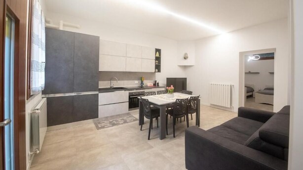 A modern apartment with a kitchen, dining area, and living room. - Sonech (Sonico)