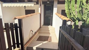 A residential building with a tiled entrance, a wooden fence, and a cactus plant. - Sofia Kite Apartment (Marsala)