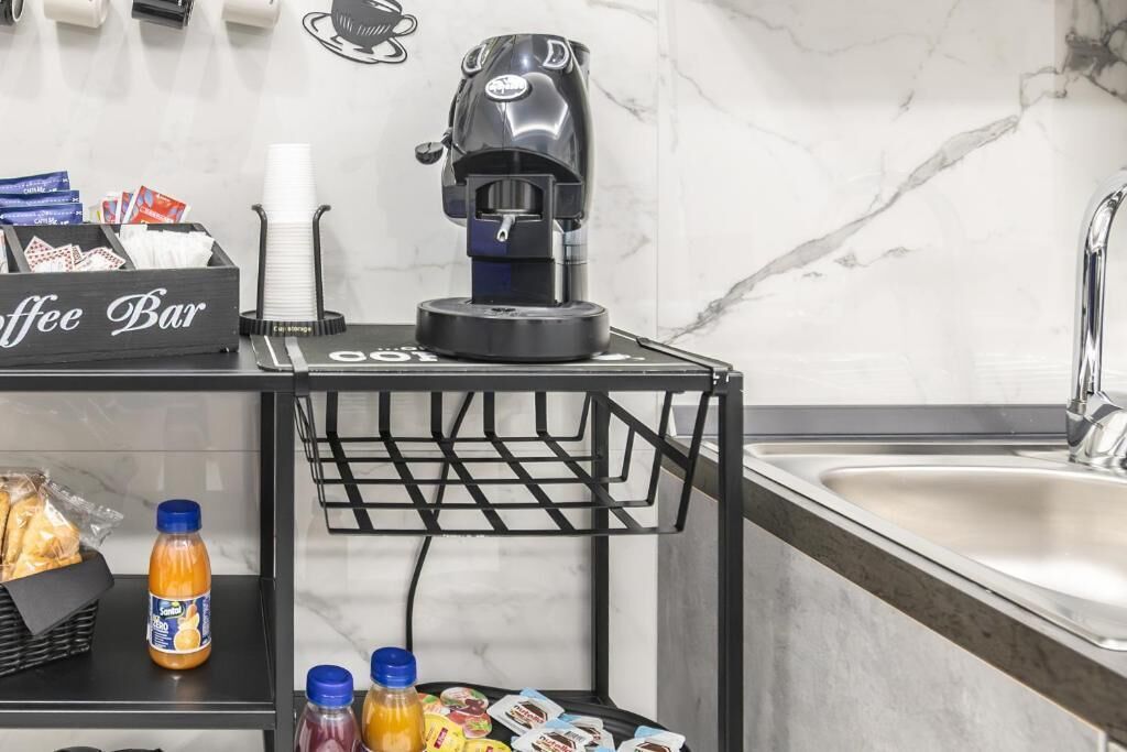A coffee bar with a coffee machine, a basket of coffee cups, and various coffee pods.