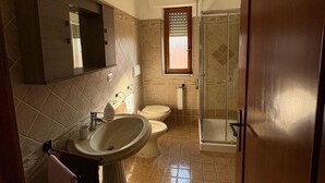 A bathroom with a sink, two toilets, a mirror, and a shower. - Perla Sul Mare (Vibo Marina)