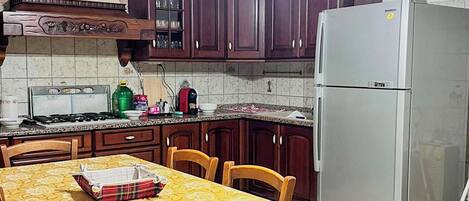 Full-sized fridge, oven, stovetop, cookware/dishes/utensils