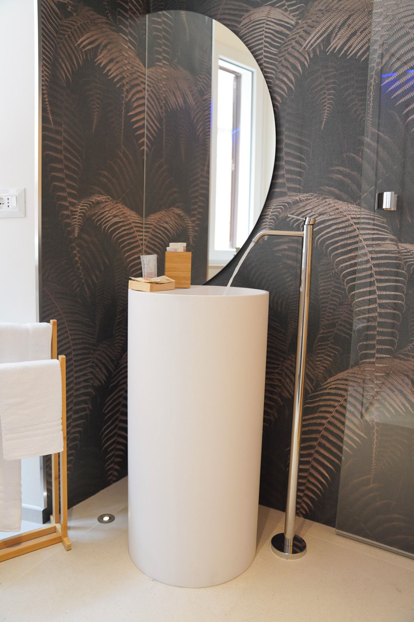 A bathroom with a white sink, a mirror, and a towel rack.
