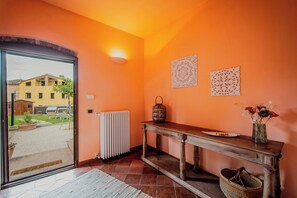A hallway with a wooden console table, a radiator, and a basket. - Holiday Home Croce (Lucignano)