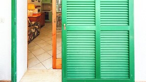 A green door leading into a room with a tiled floor, a microwave, and a cabinet. - La Casina Di Giuliana (Principina a Mare)