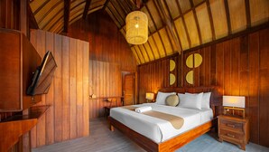 Une chambre à coucher décorée dans un style rustique, avec un lit, des tables de chevet, un luminaire suspendu et une armoire en bois.