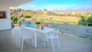 A modern outdoor dining area with a pool table, white chairs, and a scenic view of a rural landscape. - Casa Vacanze Stella Marina (Marina di Palma)