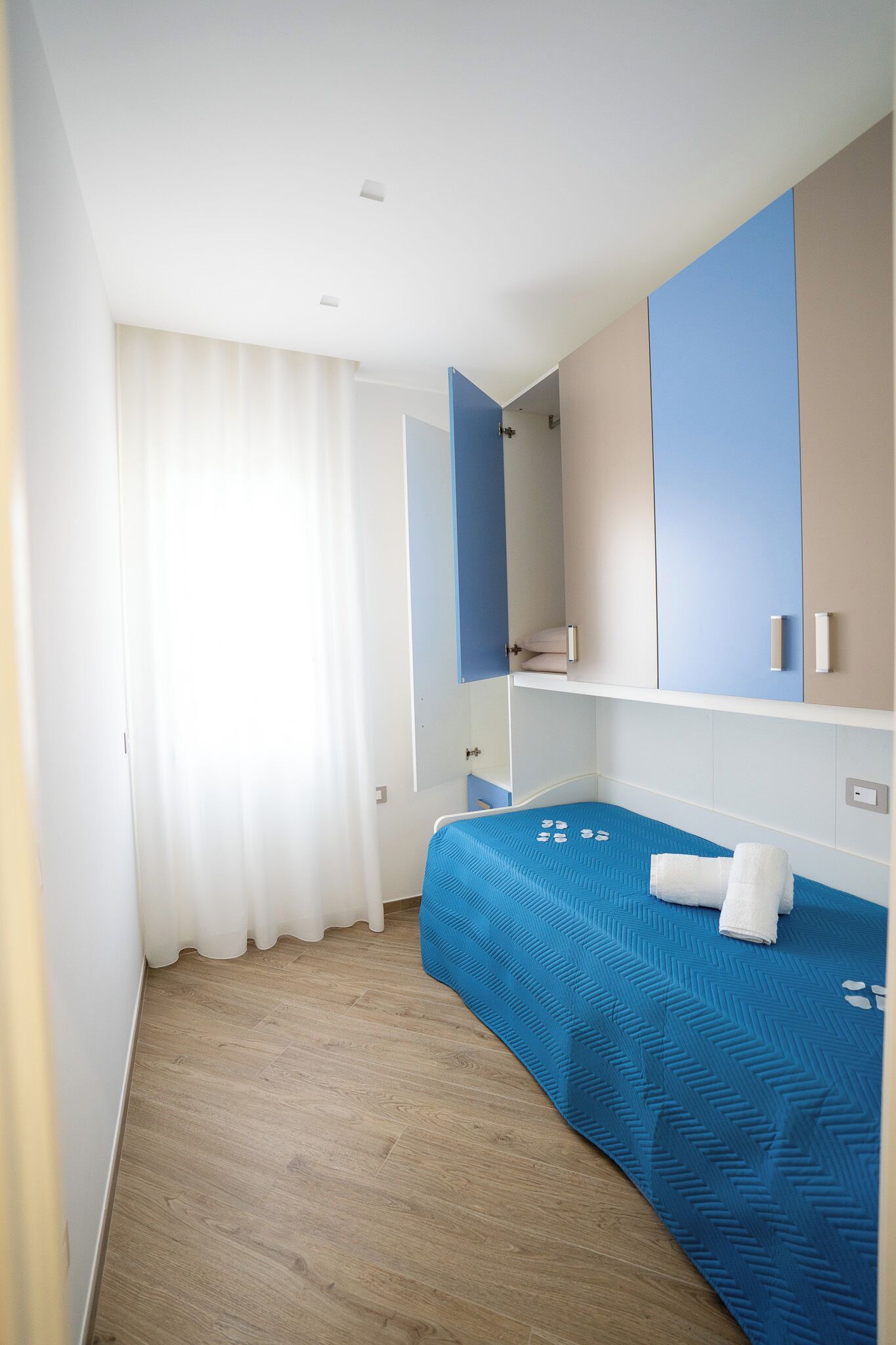 Quarto de hotel com cama, guarda-roupa e espelho.