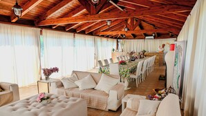 A spacious room with a high wooden ceiling, a long dining table set for a meal, and several sofas arranged for seating. - Villa Leproso (Benevento)