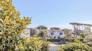 A residential area with white houses, green lawns, and a prominent tree. - Villa Magnolia (Sabaudia)