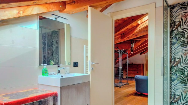 A modern bathroom with a wooden ceiling, a large mirror, and a white sink. - Casa TreSoli - Baselga di Pinè (Baselga di Piné)