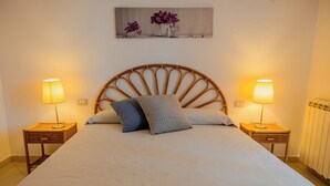 A neatly made bed with two bedside tables, each with a lamp, and a wall-mounted artwork above. - Casa Carmen (Capaccio-Paestum)