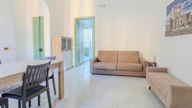 Amplia sala de estar con una mesa de comedor, dos sofás y un cuadro en la pared.