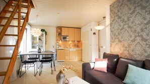 Un espacio habitable compacto con cocina, comedor y sofá.
