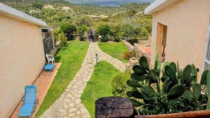 A pathway leading to a mountainous landscape with a view of a lake. - Casa Puni (Olbia)