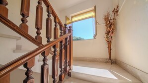 Un escalier en bois offrant une vue dégagée sur le ciel par une fenêtre ouverte.