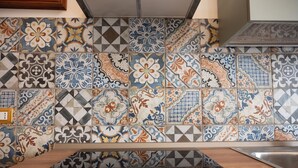 Eine Küche mit einer Wandfliese, die verschiedene geometrische und florale Muster zeigt.