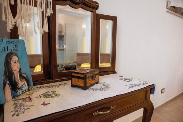 A wooden dresser with a mirror, a small wooden chest, and a decorative tablecloth. - A Casa Di Marilù (Lanciano)