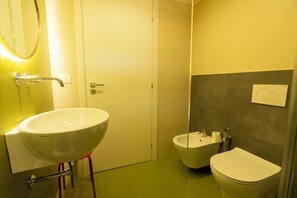 A bathroom with a large white sink, a small bidet, and a toilet. - Villa Villacolle (Marsala)
