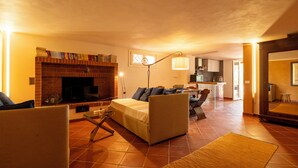A cozy living room with a fireplace, a sofa, and a dining area. - Villa Villacolle (Marsala)