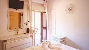 A hotel room with a bed, a bedside table, a mirror, and a wall-mounted light fixture. - Casa In Montagna Vicino Al Mare (Itala)