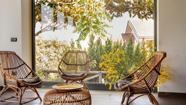 A balcony with wicker furniture and a view of trees and buildings. - Villa Petrara - Villa Con Piscina E Spa (San Mango sul Calore)