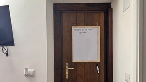 A wooden door with a whiteboard displaying a message in Italian. - B&B Nonna Cristina (Nardodipace)
