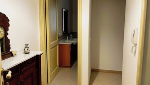 A narrow hallway with a wooden door leading to a bathroom. A white telephone is mounted on the wall. - Casa Vacanza Acquanuova (Calatafimi)