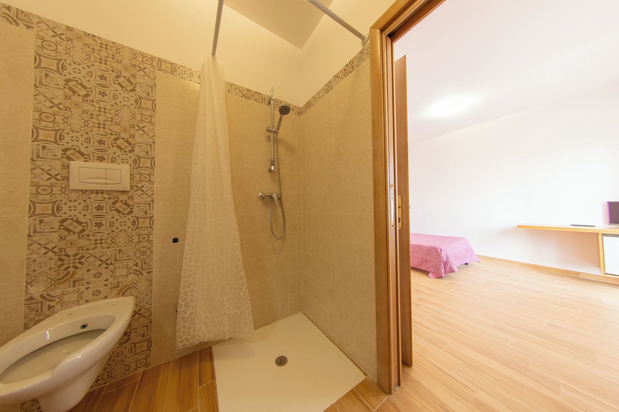 A bathroom with a shower, toilet, and a sink.