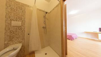 A bathroom with a shower, toilet, and a sink.