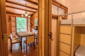 A wooden interior with a dining table, chairs, and a bunk bed. - Appartamento Fonte Eremita (Roccaraso)