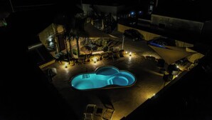 An outdoor swimming pool area with a covered seating area, a car, and a stone wall. - Casale Sammartano By L.A.Apartments (Ummari)