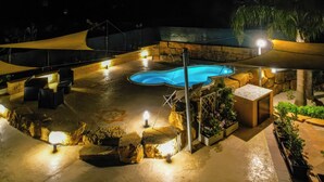 A swimming pool with surrounding seating and a shaded area. - Casale Sammartano By L.A.Apartments (Ummari)