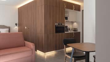 A modern living room with a sofa and a dining area with a table and chairs.