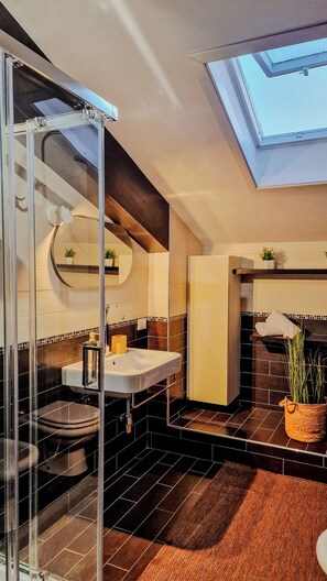 A modern bathroom with a skylight, a glass shower enclosure, a toilet, a sink, and a bathtub. - Domus Dea - Appartamento Afrodite (Mondello)