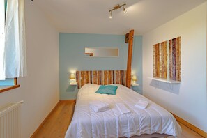 A bedroom with a bed, a wooden headboard, a mirror, wall art, and bedside lamps. - Large gîte for 10 to 14 people in a hamlet in the heart of Périgord Noir (Paulin)