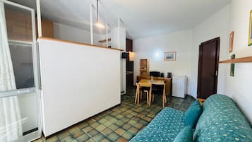 Een gezellige, compacte ruimte met een kitchenette, een eethoek en een zithoek.