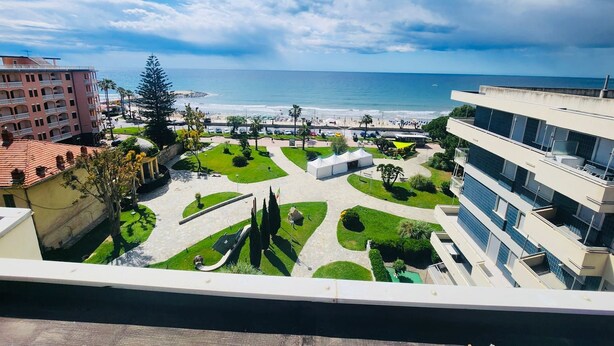 A coastal hotel with a view of the sea, a courtyard with greenery, and modern buildings. - GRAZIELLA - Fronte Mare in Centro con terrazza (Marina di Andora)