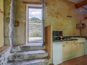 Une cuisine avec des marches en pierre menant Ă une porte, un fourneau et un four Ă micro-ondes.