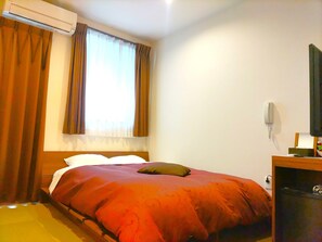 A room with a bed, an air conditioner, a window with curtains, a bedside table, and a phone. - PREMIUM TOJI (Kyoto)
